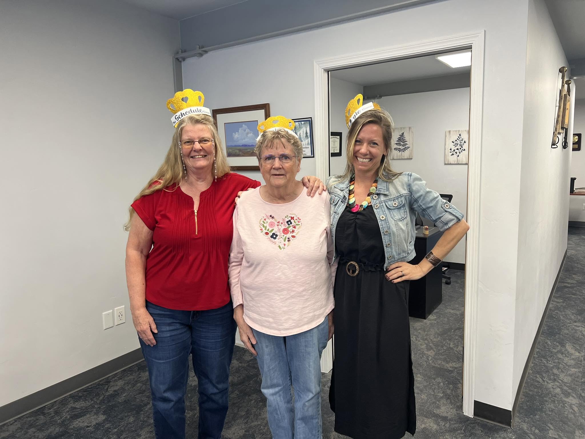 The Accurate Tax and Accounting Service team celebrating together after a tax season, wearing paper crowns in the Olathe office